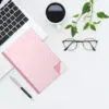 Notizbuch "Rosé" auf dem Schreibtisch mit einem Laptop