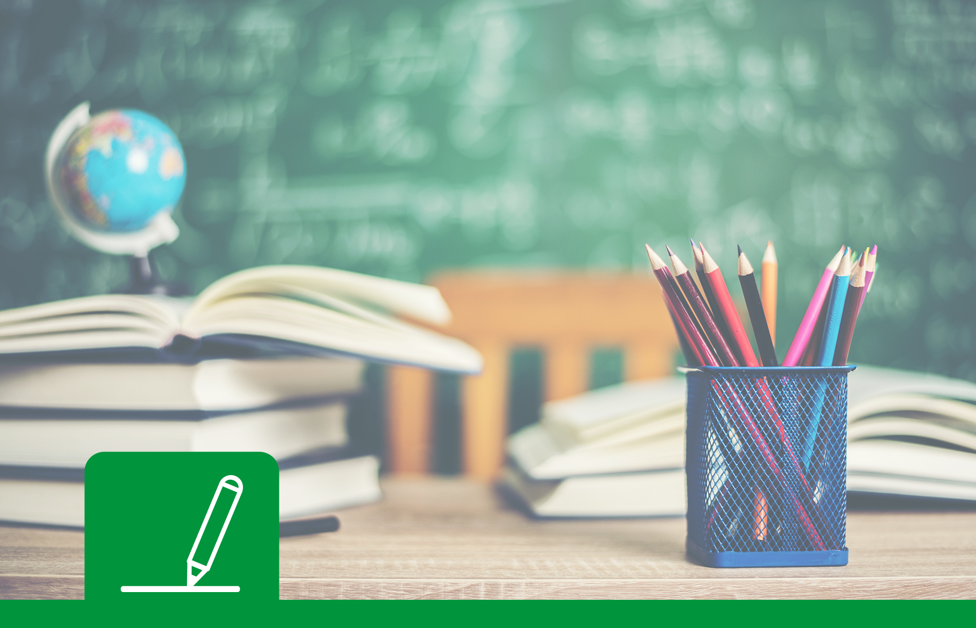 Schulschreibtisch mit Büchern und Tafel im Hintergrund